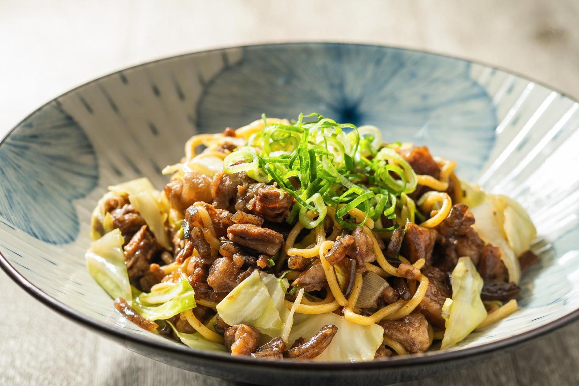 神戸メリケンパークオリエンタルホテル 神戸市 エクステリア 写真 The photo shows a serving of a dish in a stylish bowl. The dish features a mix of stir-fried noodles, likely accompanied by pieces of meat and vegetables. There is visible cabbage included, and it is garnished with finely chopped green onions on top.